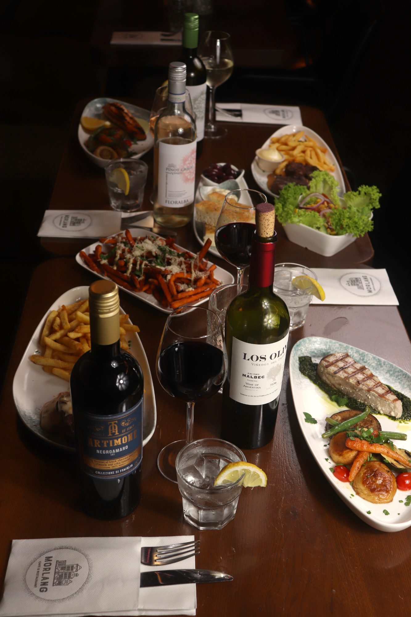 One long table with dishes to share and wine
